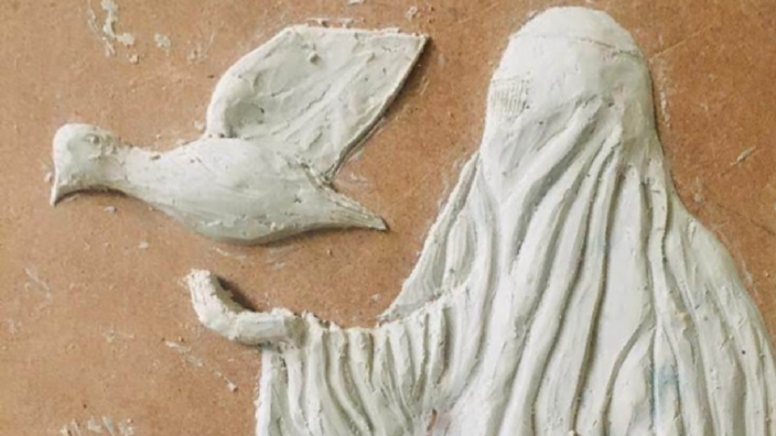 Birds and a woman veiled with burqa are sculpted in 3D from a lime-colored mass. The background is light brown. 