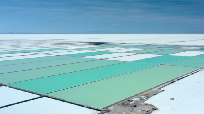 A very large landscape area is divided into many rectangular fields of the same size. The fields are turquoise and white.