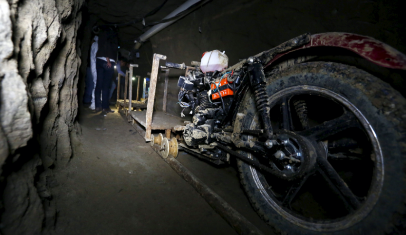 A motorcycle photographed obliquely from behind in a cave underground