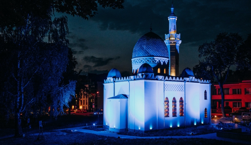 Eine blau angeleuchtete Moschee in der Nacht.