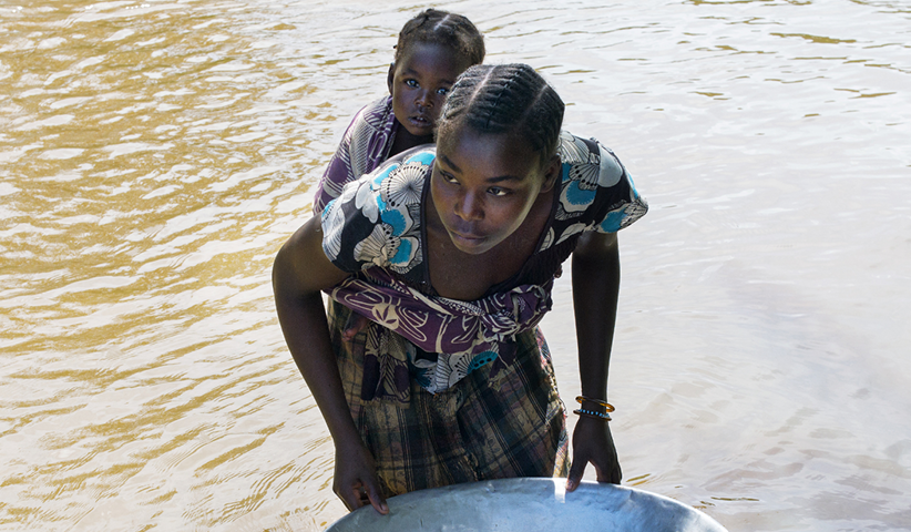 Eine Frau sucht im zentralafrikanischen Fluss Kotto nach Gold