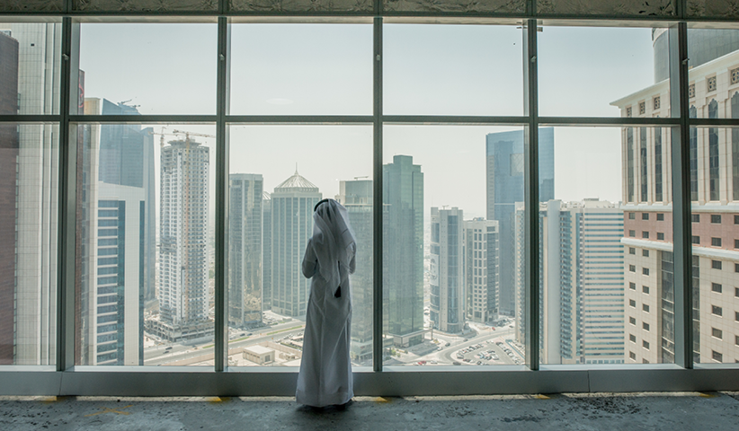 Ein Besucher einer Kunstgalerie in Doha blickt auf die Skyline des Stadtteils West Bay