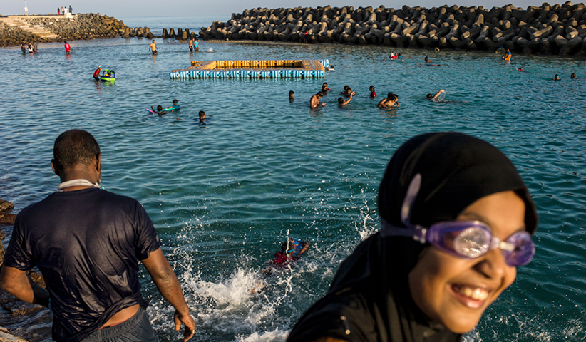 Malediver gehen an der Strandpromenade von Malé schwimmen