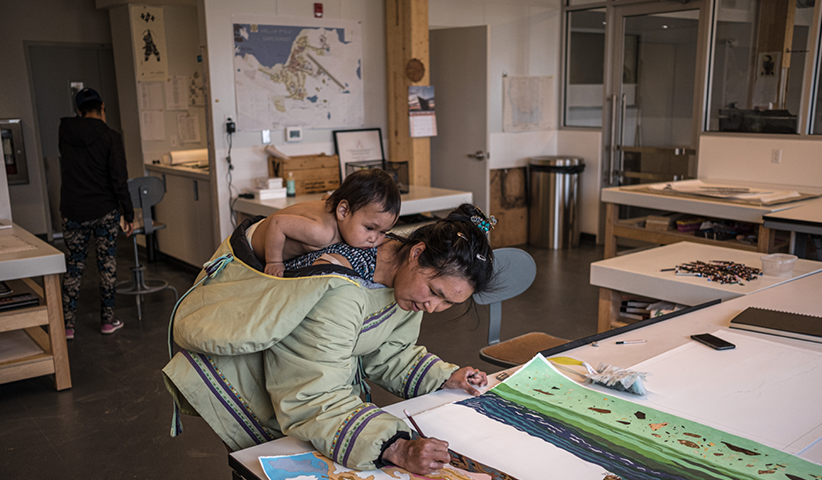An artist gives her painting the final touch at the Cape Dorset Art Centre